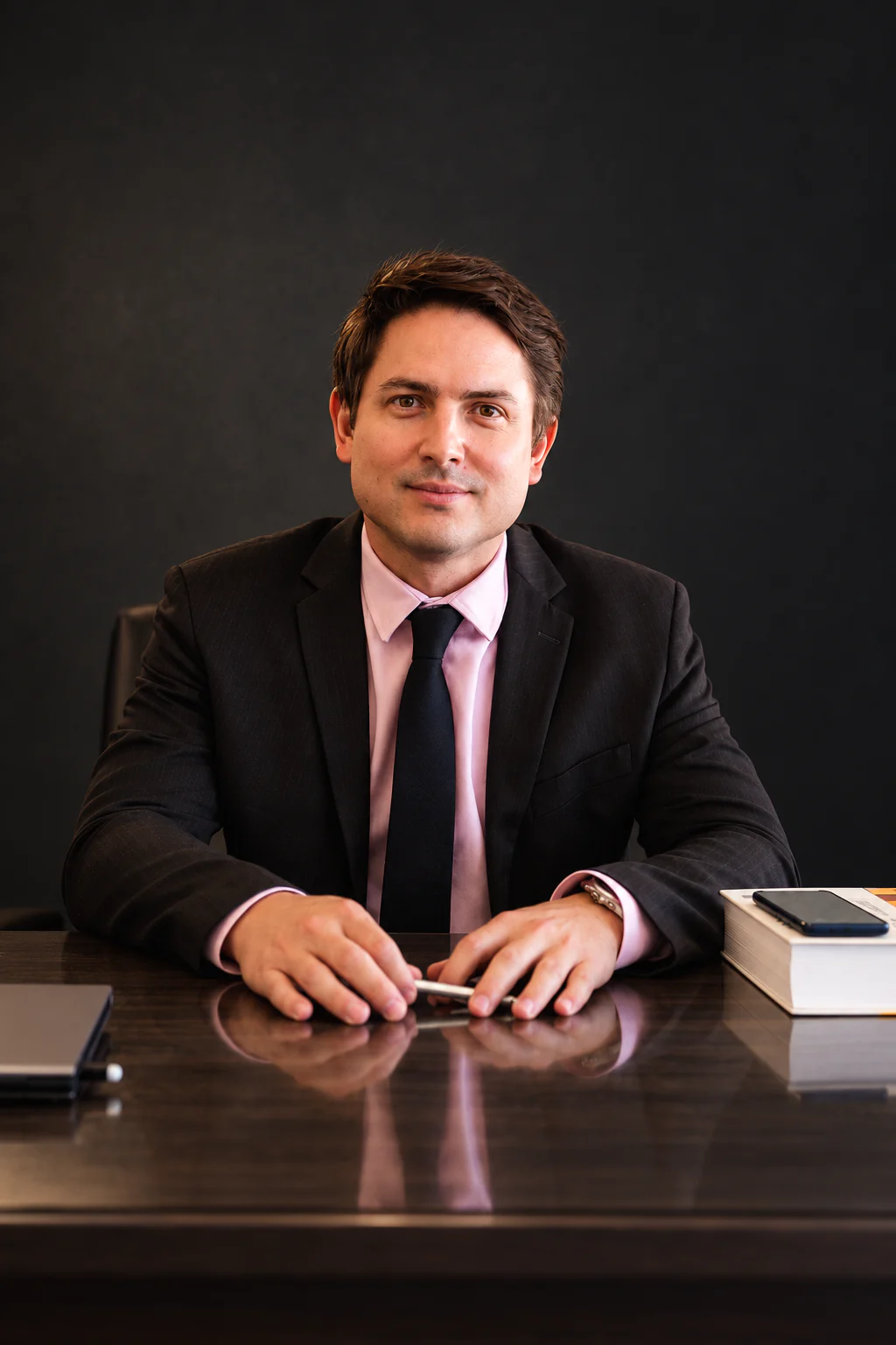 Péricles Emrich Campos Segundo, de terno escuro, sentado à mesa do escritório